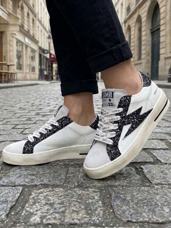 Basket femme semerdjian , modele Maya C780, en cuir blanc avec paillettes décoratives et éclair iconique bronze. A porter avec un jean anthracite, lifestyle au quotidien