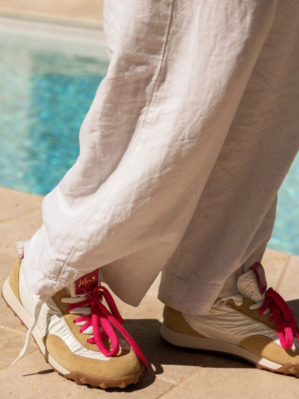 Baskets femme Moni marque italienne lacets rose fuchsia vif sneakers printemps été 2026 portées avec pantalon lin blanc bord piscine lifestyle estival