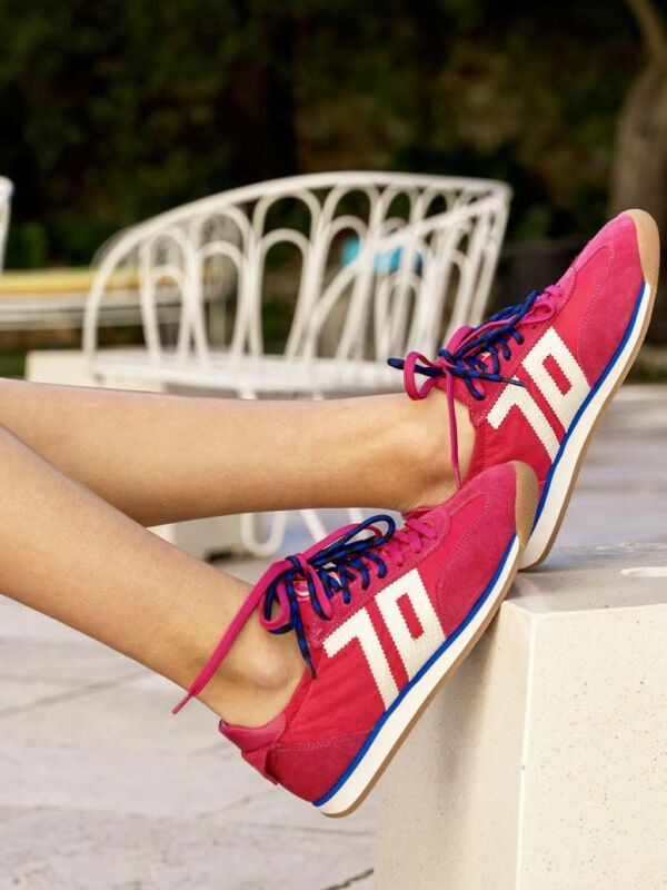 Sneakers femme Back 70 rose avec double lacet rose et bleu, bandes blanches contrastées et semelle gomme, portées en extérieur