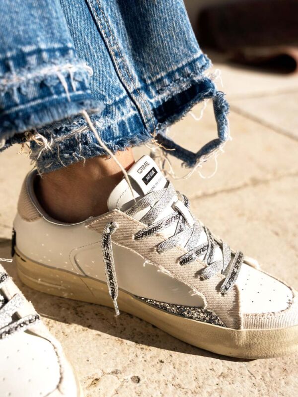 Sneakers femme Crime London Sk8 Deluxe Desert Stardust blanches avec empiècements beige sable, lacets imprimés et semelle effet vintage, portées avec un jean