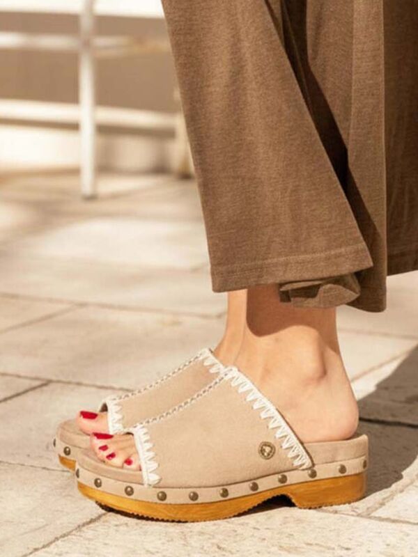 Sabot en bois femme rose sable à talon bas MOU en daim premium, vue de profil portée, avec bride unique, couture signature et clous métalliques