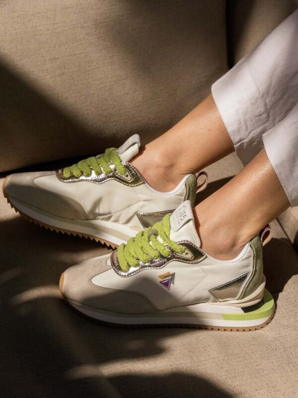 Sneakers 0-105 Lenox Blooming blanches lacets verts fourrure détails métalliques argentés posées sur canapé beige jeux d'ombres et lumière naturelle