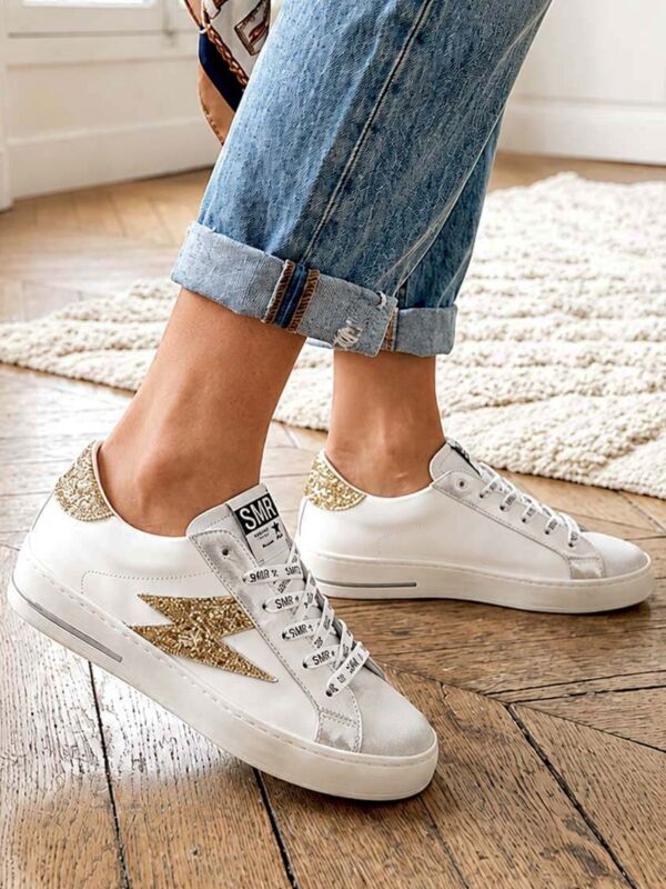 Sneakers femme blanches et dorées Maya C785, collection automne-hiver 2026-2027, baskets tendance en cuir avec détails pailletés dorés, style casual chic.