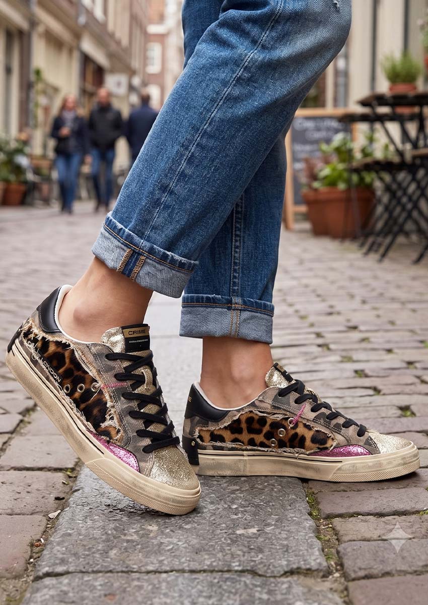 Inspiration Look : Porter la sneaker Crime London Léopard au quotidien Idée de look street style femme avec la basket Crime London léopard et militaire portée avec un jean denim bleu retroussé. Style urbain et casual chic dans une rue pavée pour inspirer une tenue tendance automne-hiver.