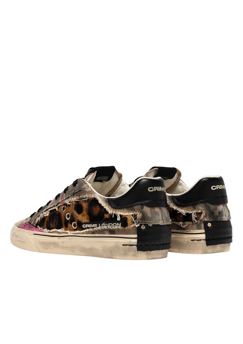 Zoom sur les détails de la basket Crime London – Finitions Talon Vue arrière des sneakers Crime London femme mettant en valeur le contrefort en cuir noir marqué du logo de la marque. Une basket style rock chic aux finitions soignées avec rivets métalliques et empiècements déstructurés.