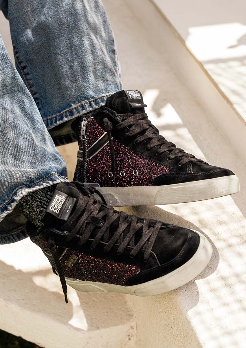 Street style hiver : baskets paillettes bordeaux Crime London avec jean wide leg Street style : baskets Crime London RECUT HIGH paillettes bordeaux avec jean large, portées sur marches blanches au soleil