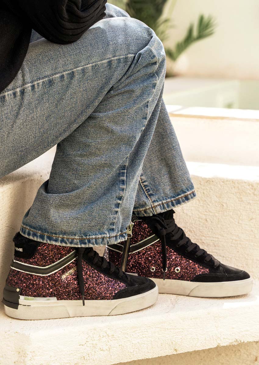 Inspiration tenue : sneakers montantes bordeaux fourrées, pull noir et jean wide leg Look femme : pull noir, jean large bleu et baskets montantes Crime London paillettes bordeaux, esprit méditerranéen