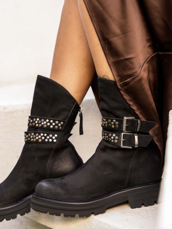 Détail des bottines noires Wash Nero portées : lanières cloutées, boucles argentées et zip arrière