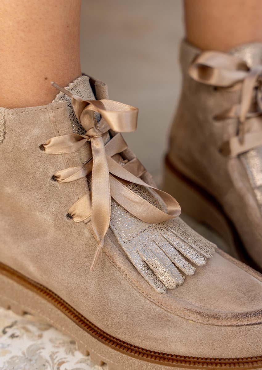 Minka Design – Détail bottine Luana Velour : lacets satin & franges dorées | Corner-Shoes.com Minka Design Luana Velour : lacets ruban de soie dorée noués et franges pailletées de la bottine beige en daim