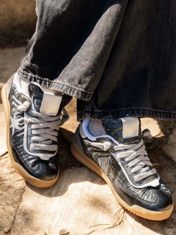 Moni Shoes Sneakers Femme Anthracite Effet Matelassé Avec Étoile, vue de face sur sol en pierre, style streetwear chic.